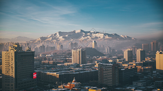 新疆乌鲁木齐市清晨城市日出风景图雪山高清图片素材