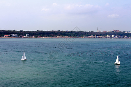 涠洲岛碧绿色海边浪花帆船运动高清图片