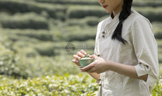 茶园里的采茶姑娘拿着茶杯特写图片