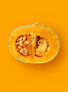 切开南瓜在橙黄色背景中的切开一半的小南瓜背景