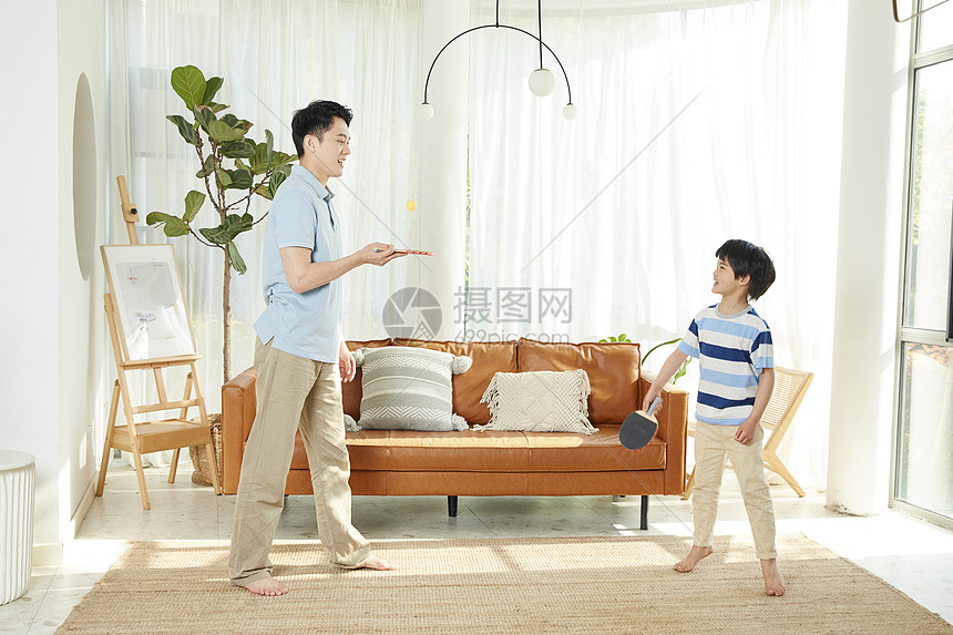小男孩和爸爸在客厅打乒乓球图片
