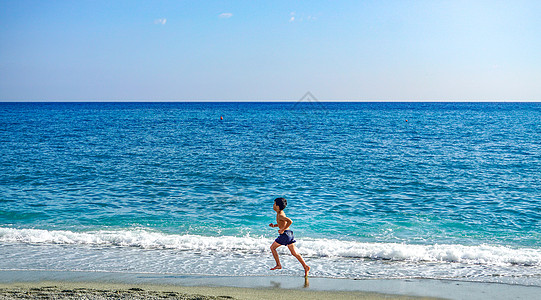 蓝色海水海边奔跑的小男孩背景