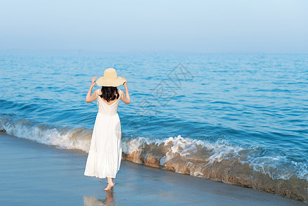 夏季旅游海边沙滩散步的美女背影背景