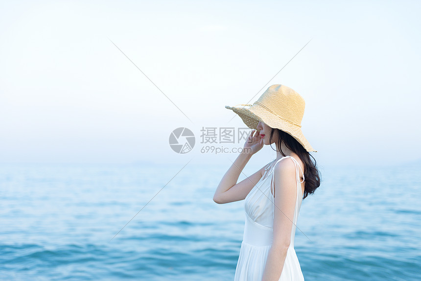 海边戴草帽的女生侧影