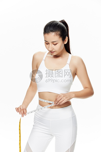 运动美女用皮尺测量腰围图片