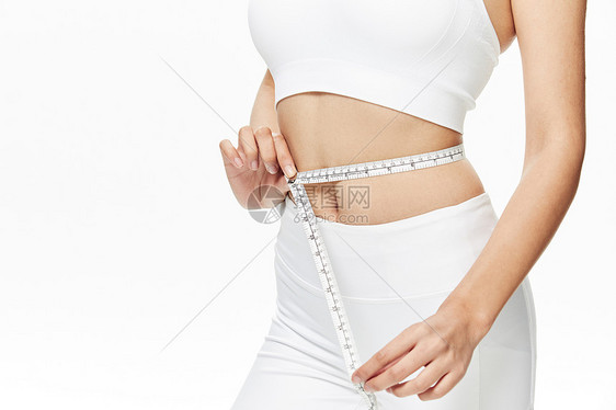 运动美女用皮尺测量腰围图片