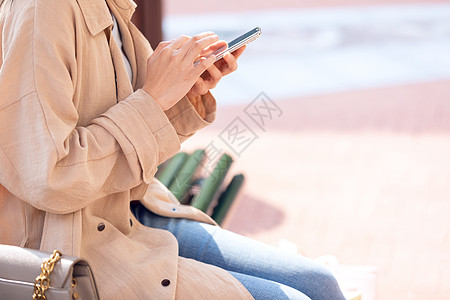 女人手机聊天青年女性坐在椅子上休息玩手机背景