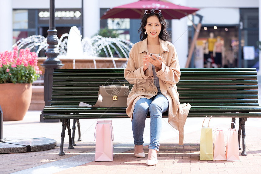 青年女性坐在椅子上休息玩手机图片