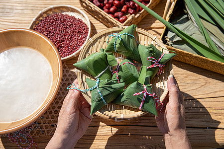 端午节老人户外包粽子特写图片