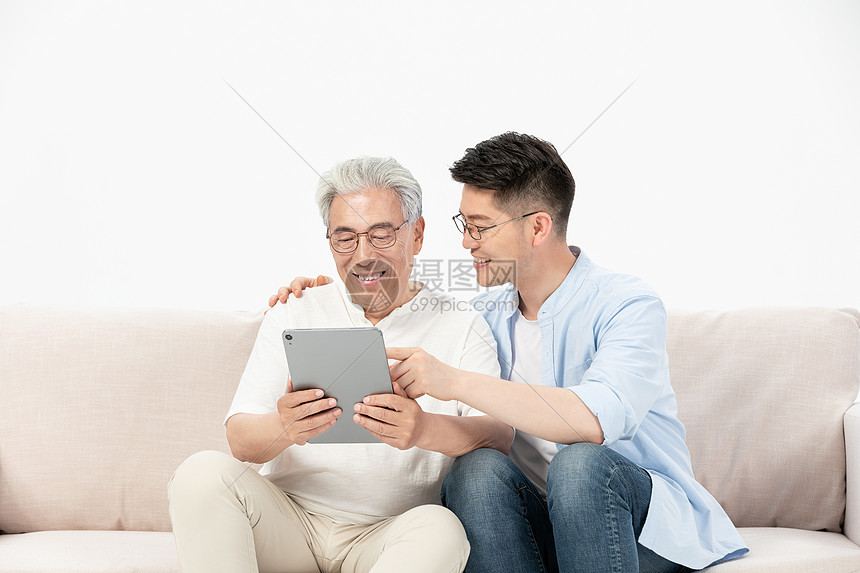 中老年父子沙发上看平板电脑图片