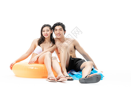夏日泳装情侣坐在游泳圈上高清图片