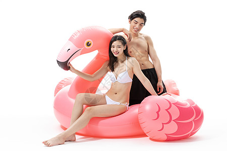 夏日泳装情侣坐在火烈鸟上高清图片
