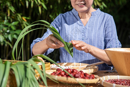 端午节户外奶奶包粽子特写图片