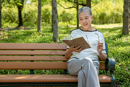 老年女性户外公园看书背景图片