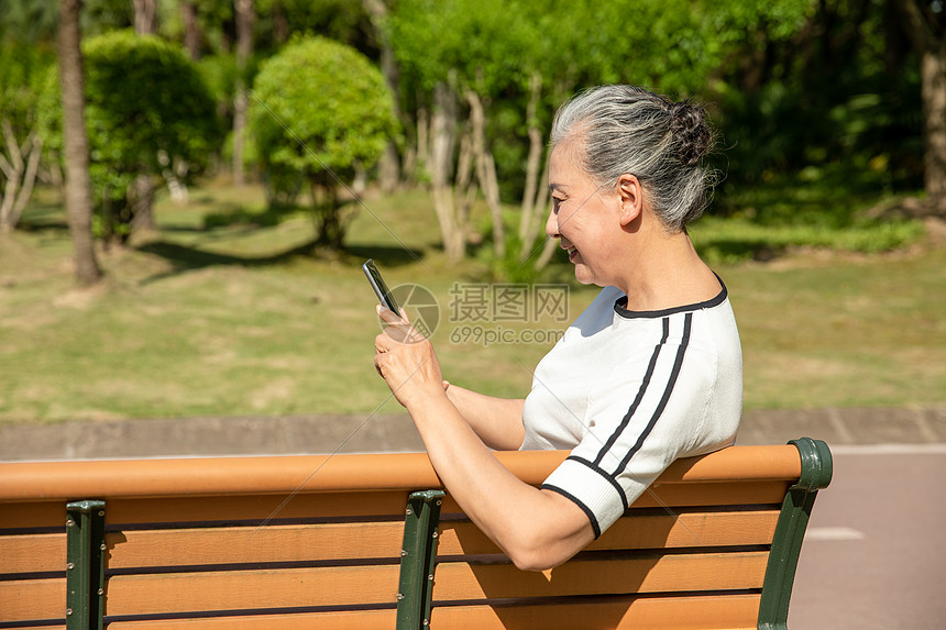 老年女性户外看平板电脑图片