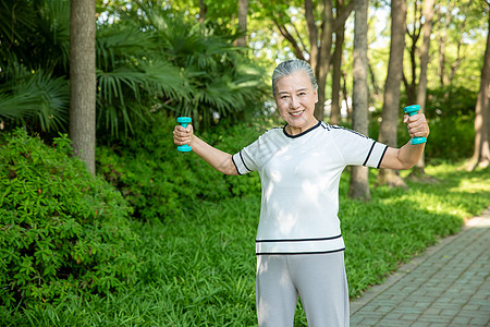 老人运动老年女性户外公园哑铃运动背景