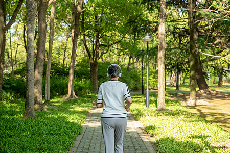 老年女性户外公园跑步听音乐高清图片