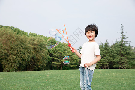 在户外吹泡泡的小男孩图片