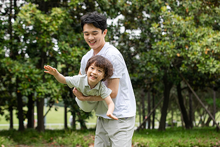 抱着桃子的男孩爸爸抱着儿子公园里嬉戏背景