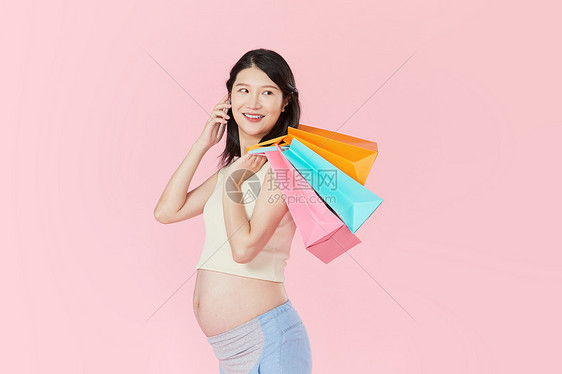 孕妇手拿购物袋打电话图片