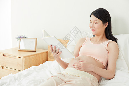 孕妇躺着床上看书图片
