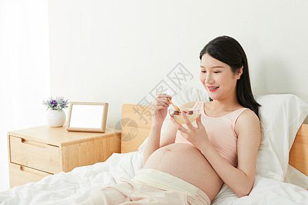 孕妇躺在床上吃燕窝高清图片