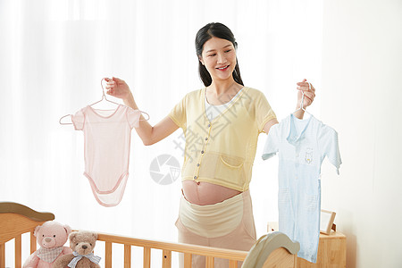 孕妇拿着宝宝衣服背景图片