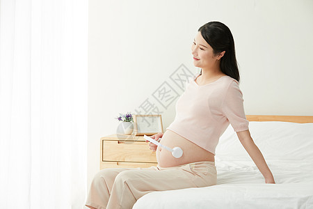孕妇用耳机给宝宝听音乐背景图片