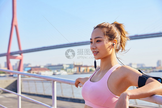 运动美女戴蓝牙耳机听音乐图片