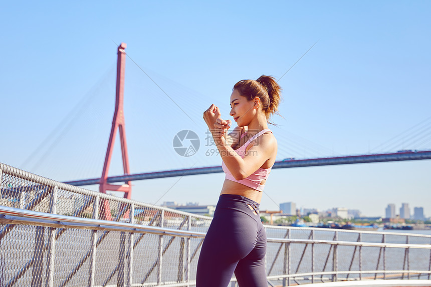 运动美女江边热身运动图片