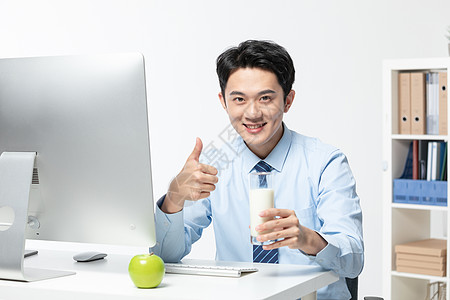 年轻商务男士在办公室喝牛奶高清图片