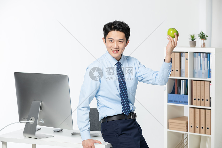 商务男士办公室吃苹果图片