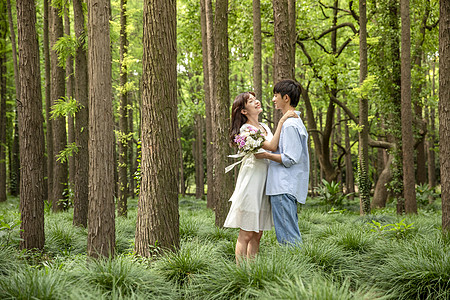 拿手机的女人青年情侣公园拥抱背景