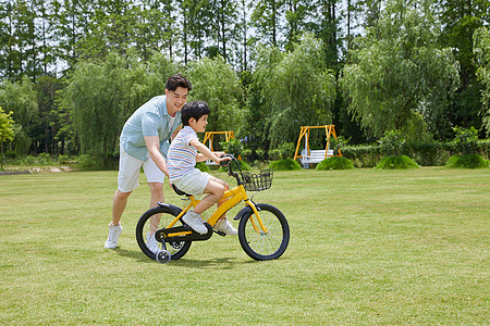学骑自行车爸爸陪伴小男孩骑自行车背景