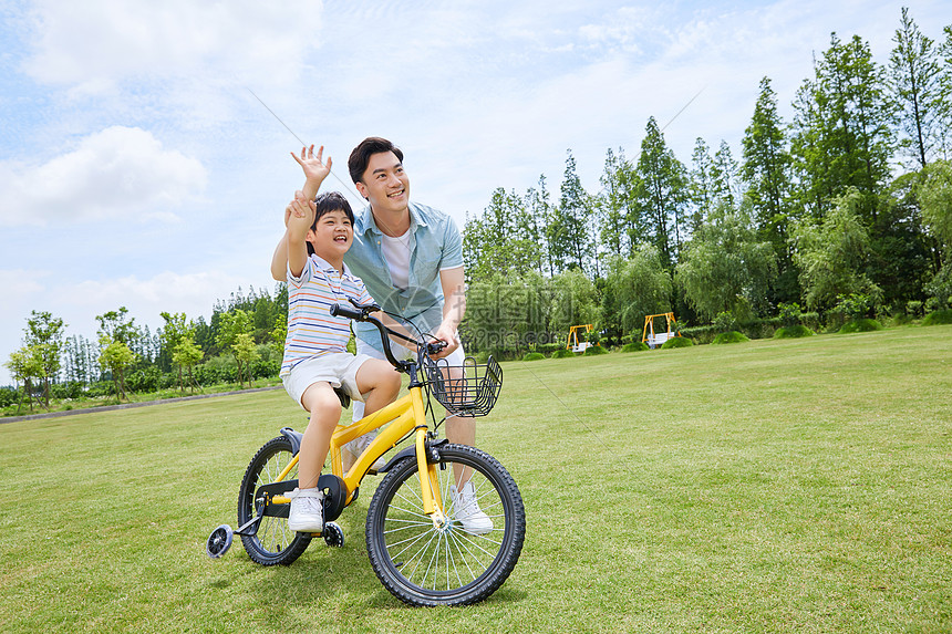 爸爸陪伴小男孩骑自行车图片