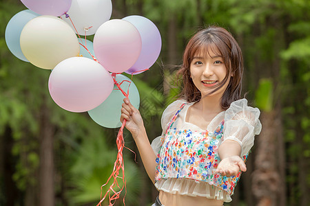 青年女性公园拿着气球背景图片