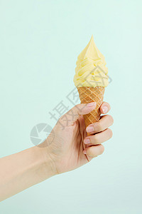 手拿芒果奶油冰淇淋甜筒背景图片