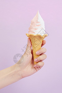 手持草莓奶油双色冰淇淋甜筒背景图片