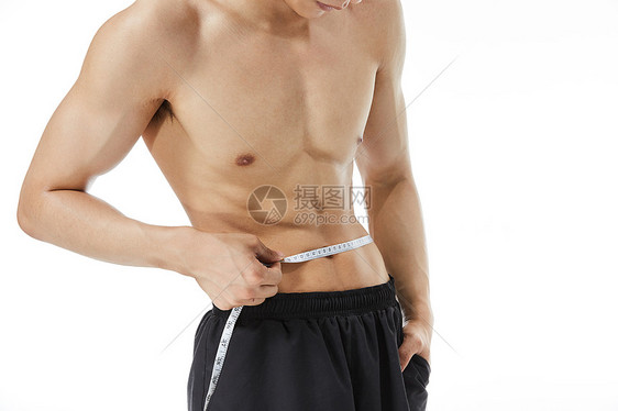 量腰围的健身男性特写图片