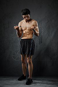 健身拉力绳使用拉力绳健身训练的运动男性背景