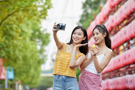 闺蜜出游季美女闺蜜旅行出游吃冰淇淋拍照背景