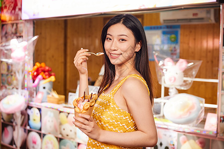 美女逛夜市地摊吃鸡蛋仔冰淇淋背景图片