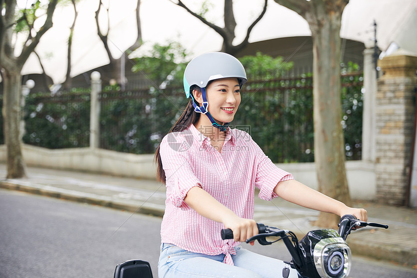 年轻美女骑电动车低碳出行