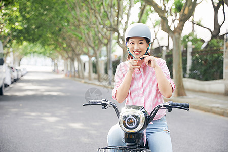 户外骑行美女户外骑电动车戴头盔背景