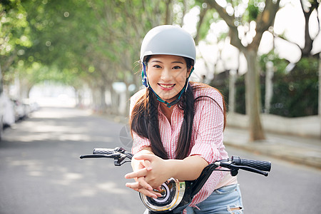 美女户外骑电动车戴头盔背景图片