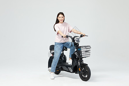 青年女性低碳出行骑电动车图片