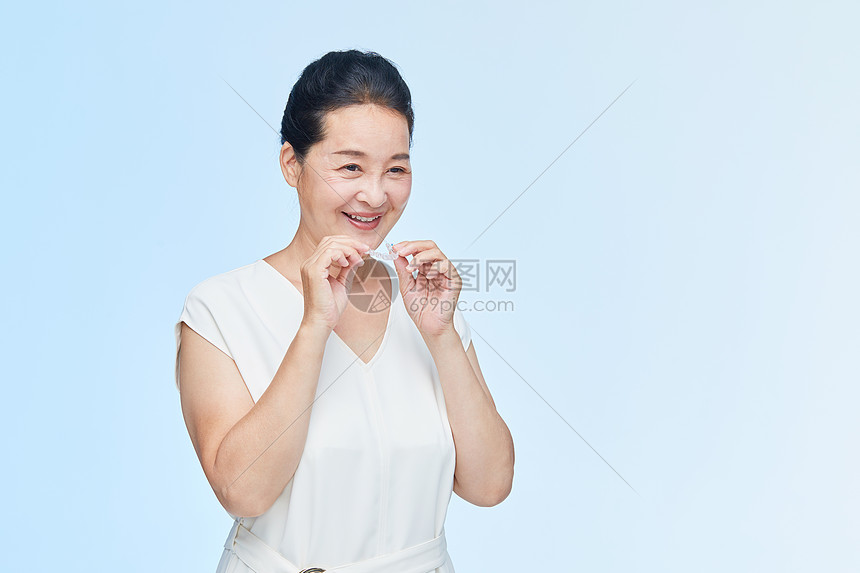 中年女性手拿牙套展示图片