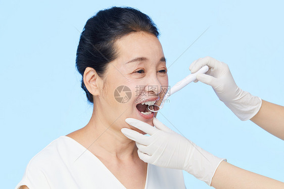 医生给中年女性检查牙齿图片