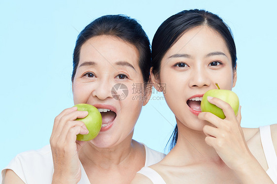 年轻美女和中年女士一起咬苹果动作图片