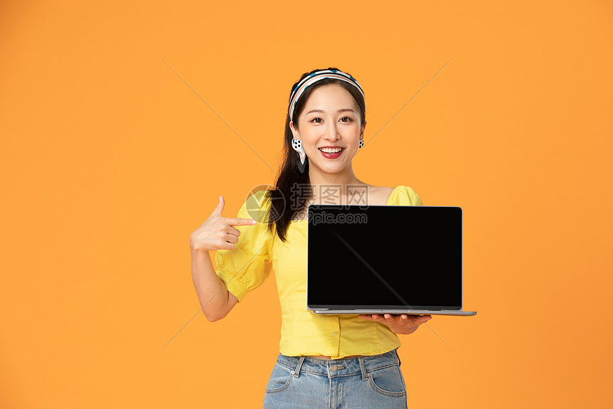 活力女性手拿笔记本电脑图片